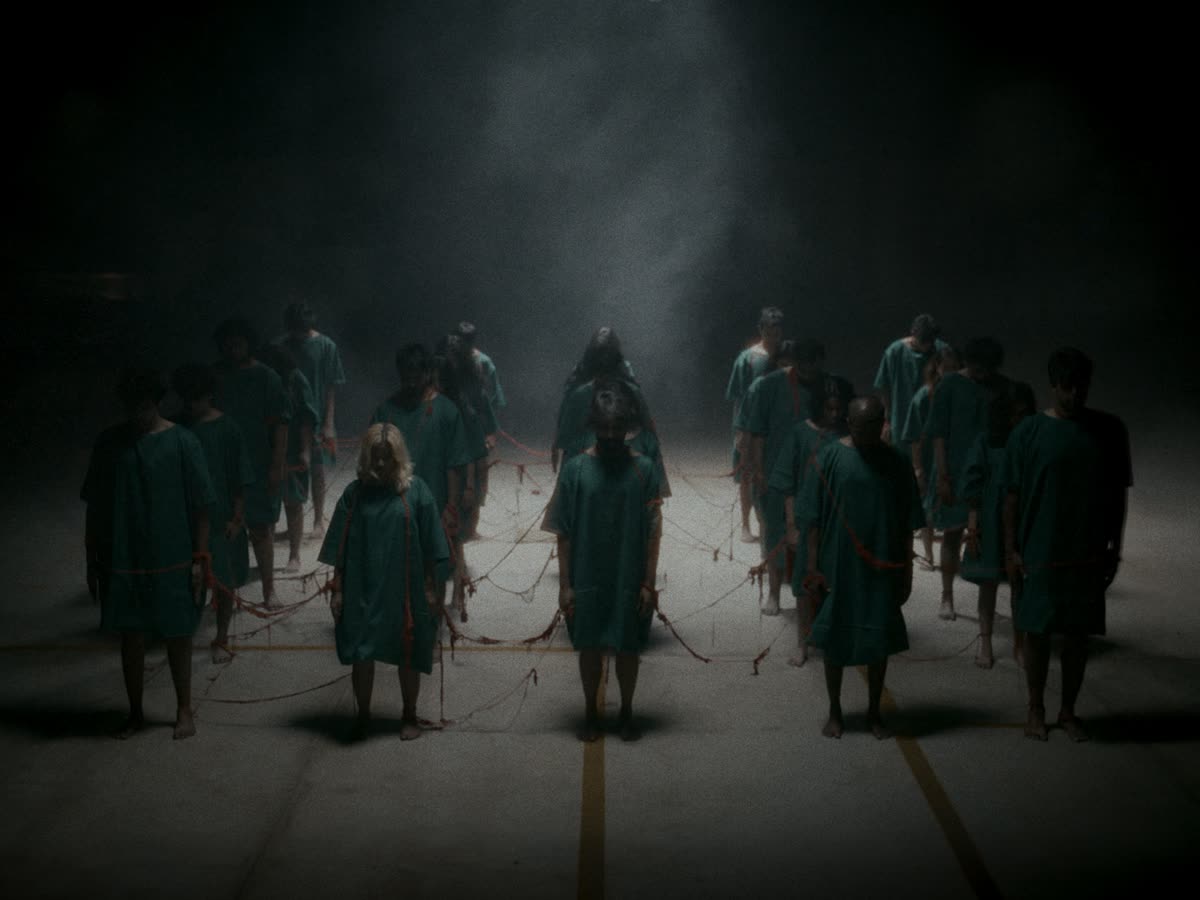 Rows of figures in green robes stand in haze